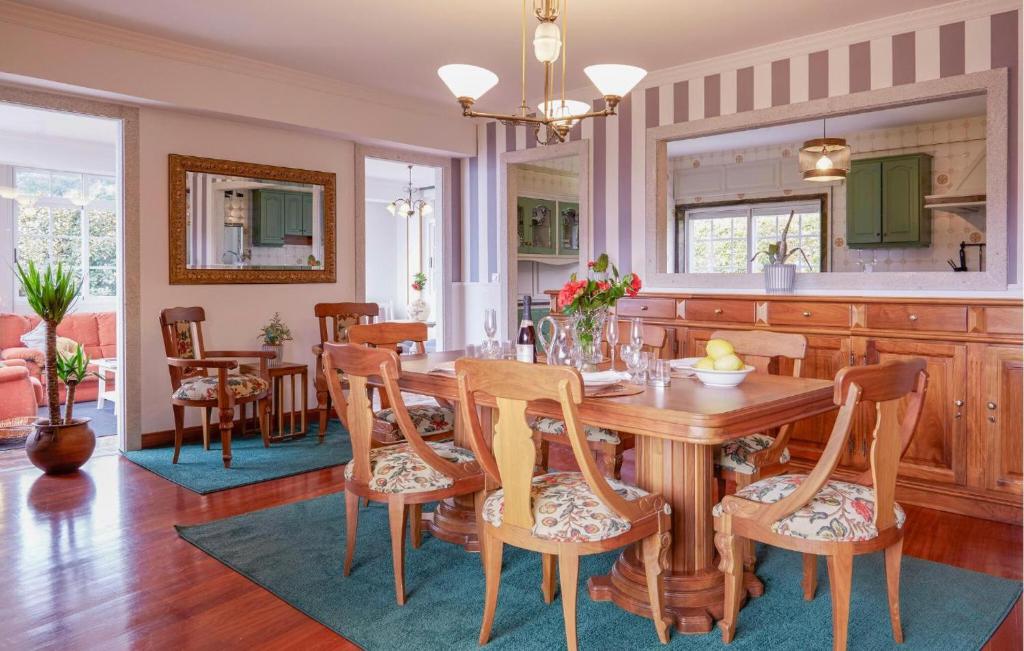 a kitchen and dining room with a wooden table and chairs at Villa Rosa Luxury Singular in Padrón