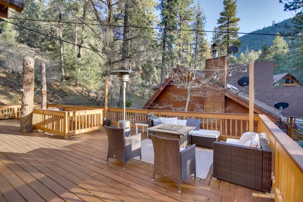 a wooden deck with chairs and a table on it at Peaceful and Idyllic Forest Cabin with Pool Table in Pine Mountain Club