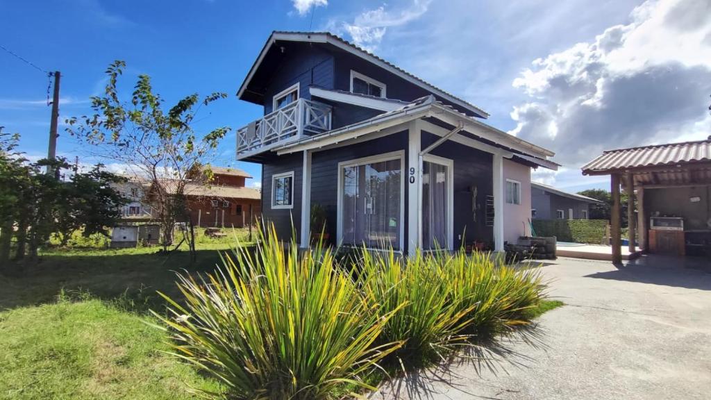 a blue house with a balcony on top of it at Chalé do Alemão in Imbituba