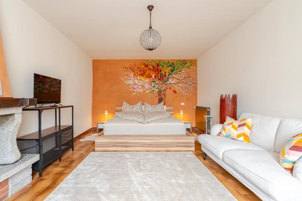 a living room with a couch and a painting on the wall at Puravida 4seasons - Nature Hideaway in Arveaco