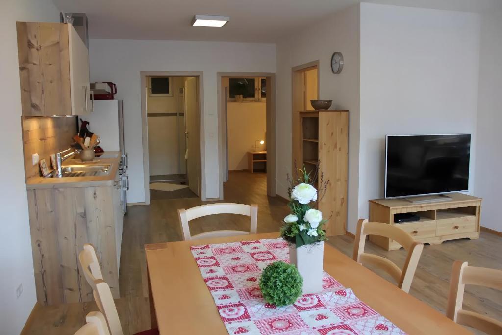 a kitchen and a dining room with a table with a flower on it at Haus Beilerstädtle in Oppenau