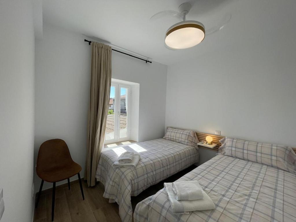 ein Schlafzimmer mit zwei Betten und einem Fenster in der Unterkunft Las Calas departamento ideal! in Sotillo de la Adrada