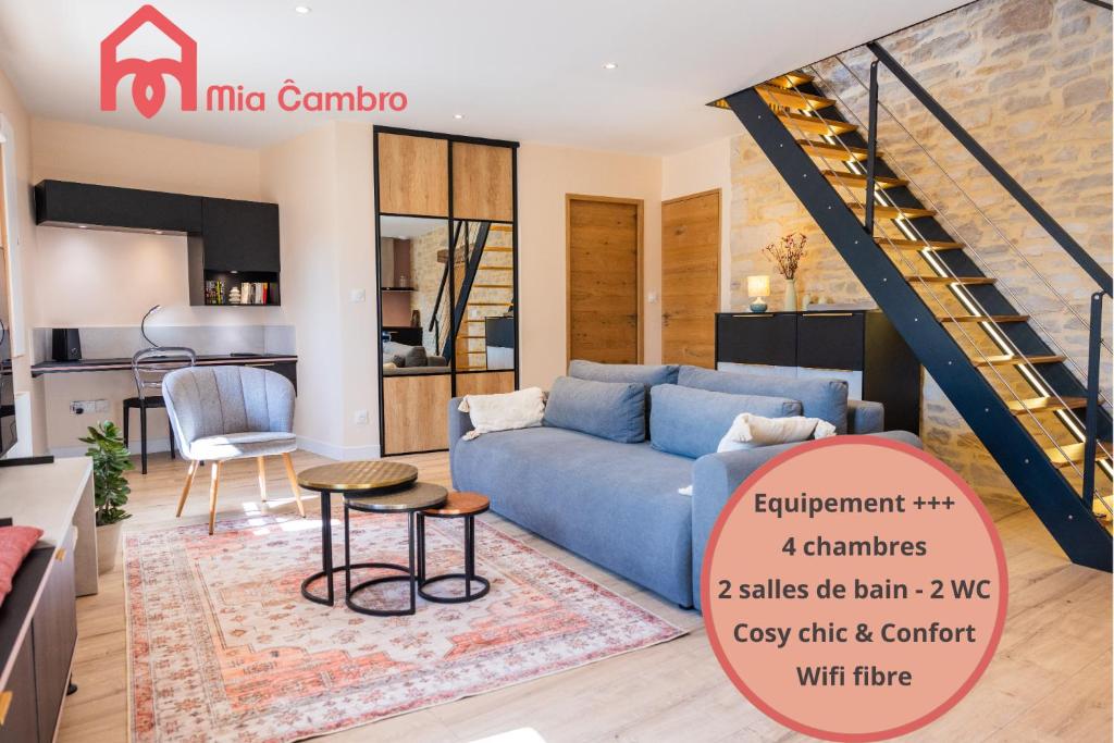 a living room with a blue couch and a kitchen at Mia Cambro in Tournus