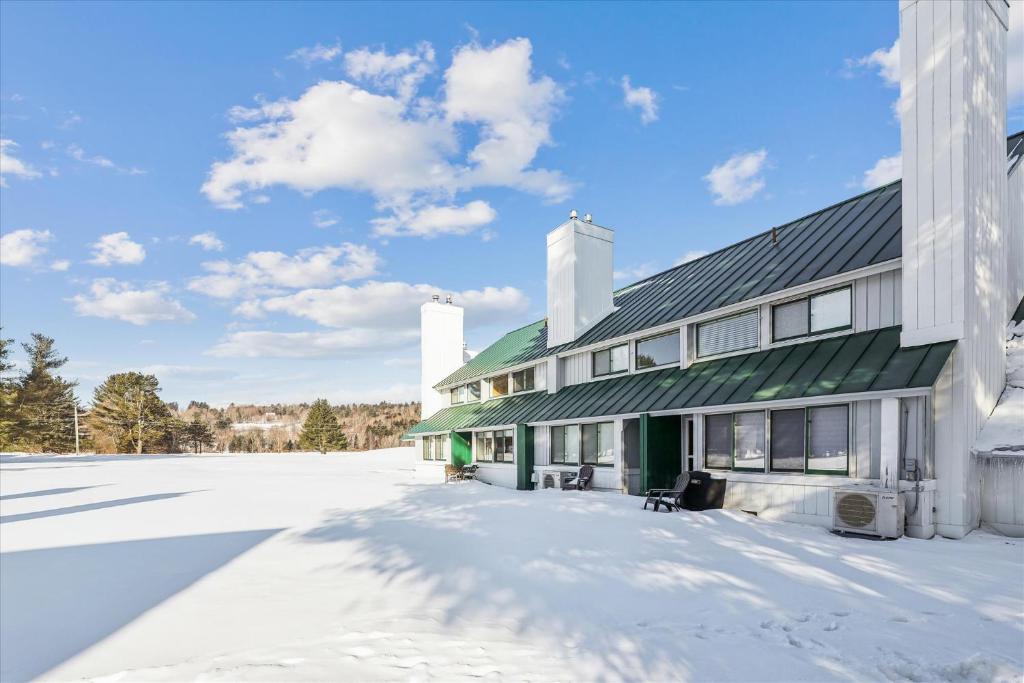 a large building with snow on the ground at Village Green 10C in Stowe
