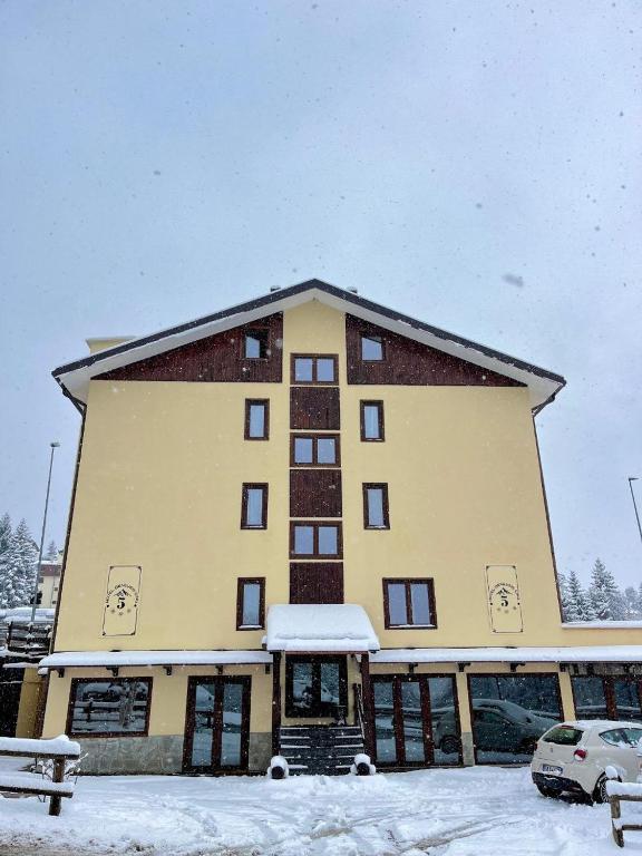 a large building with snow in front of it at Hotel Genevris Cinq in Sauze dʼOulx