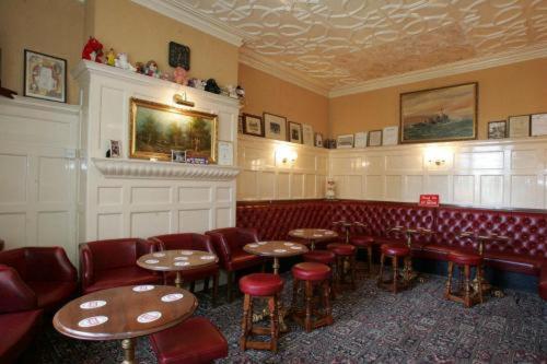 un restaurant avec des tables et des tabourets dans une pièce dans l'établissement The Langham Hotel, à Northampton