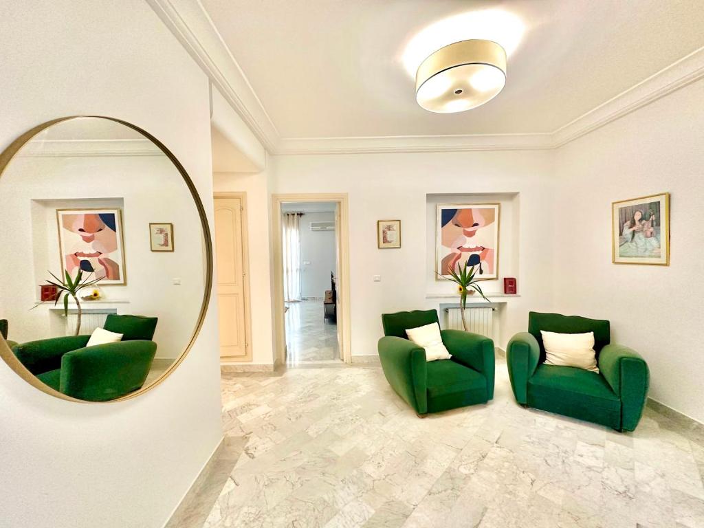 a living room with green chairs and a mirror at Safran II Appartement très central avec Terrasse à la Marsa in Dar el Ouzir
