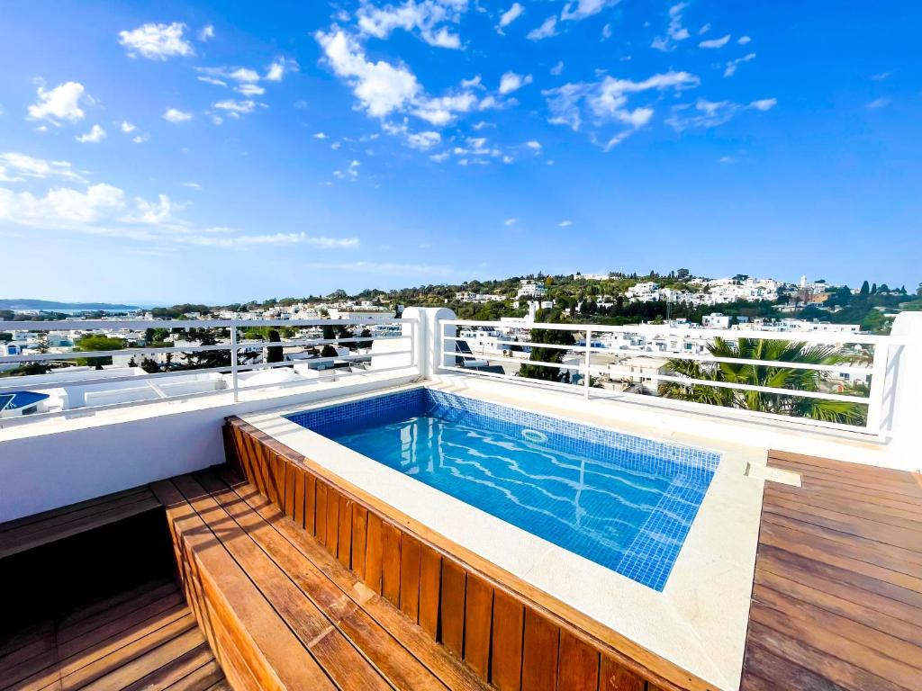 Dar Mimoun BeyPanoramic View : Enjoy a hot swim in Sidibou的楼顶带游泳池的阳台
