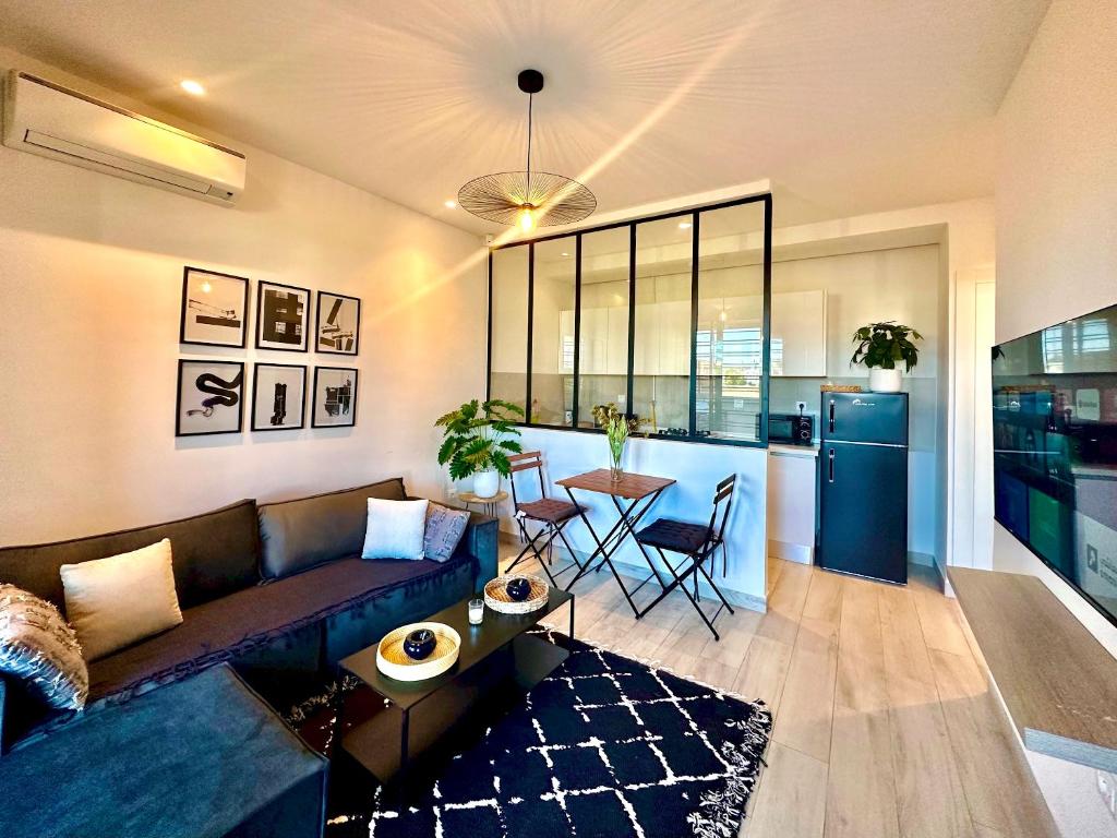 a living room with a couch and a table at C1 Jade new cozy 1 bedroom with garden in Dar el Haj Ahmed Souid