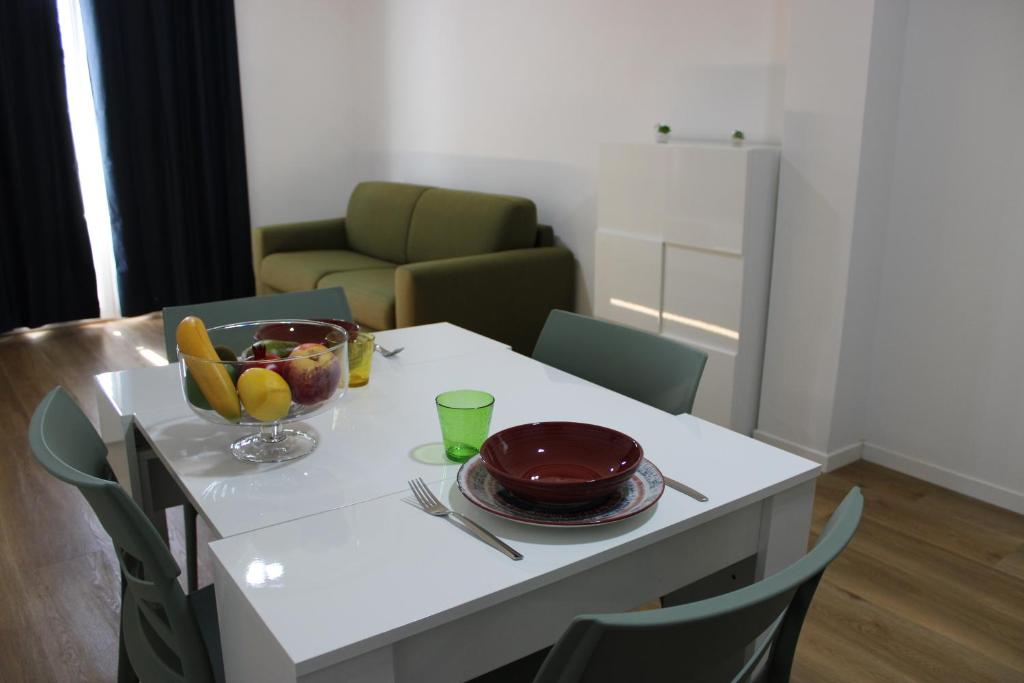 a white table with a bowl of fruit on it at Flamingo Houses in Quartu Sant'Elena