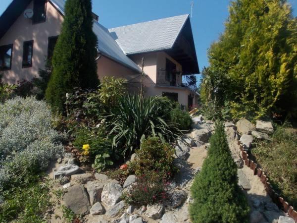 a house with trees and plants in front of a yard at Salamonówka in Szlachtowa