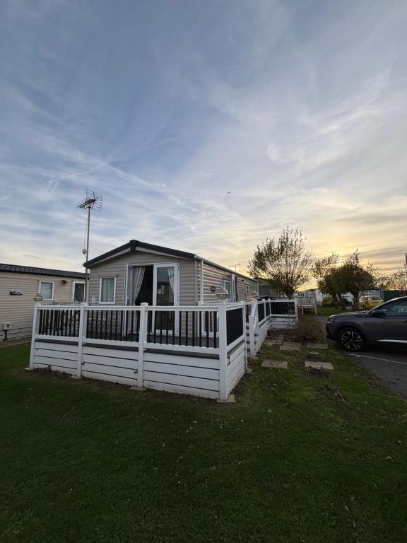 una casa con una cerca blanca en un patio en Seaview Holiday Rentals - Hailsham, en Chestfield