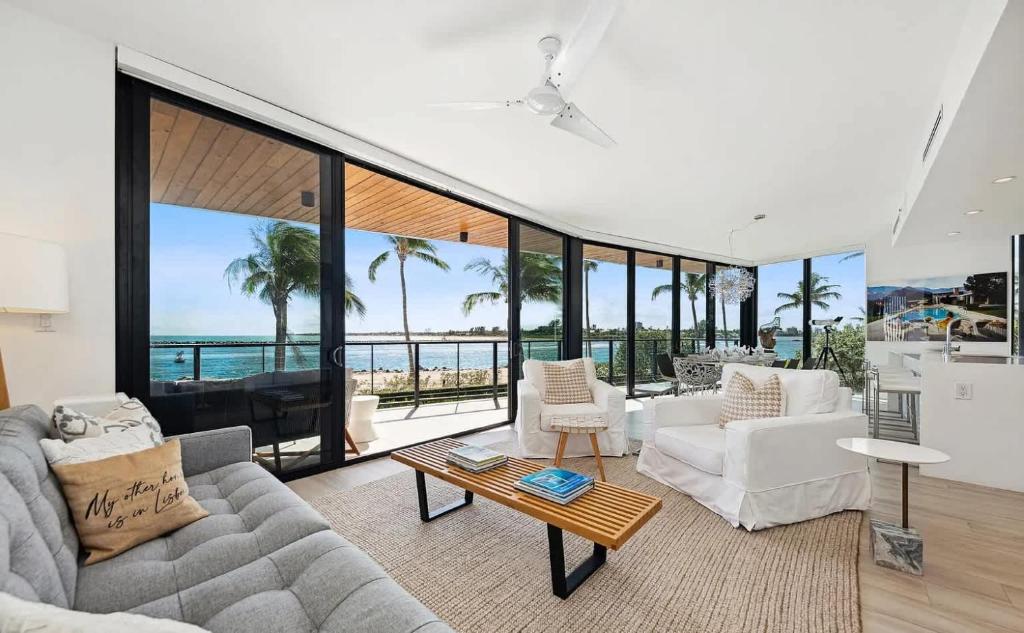 パーム・ビーチ・ショアーズにあるCozy Three-Bedroom Waterfront Apartment with Scenic Viewsの白い家具付きのリビングルームが備わり、海の景色を望めます。