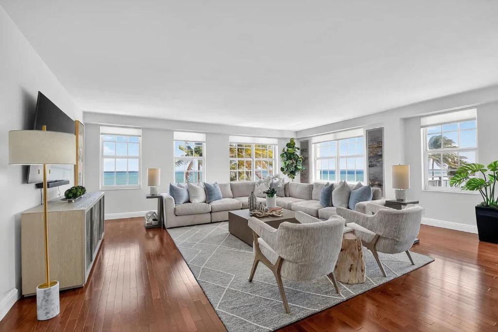a living room with a couch and a tv at Direct Oceanfront Three-Bedroom Luxury Apartment with Large Terrace in South Palm Beach