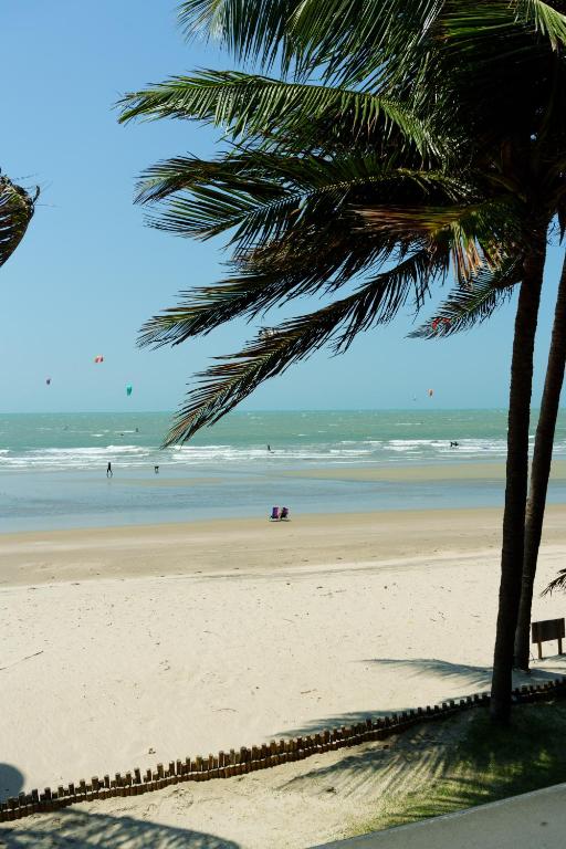 a view of a beach with palm trees and the ocean at Casa PESQUEIRA Preá - Frente Mar! in Prea