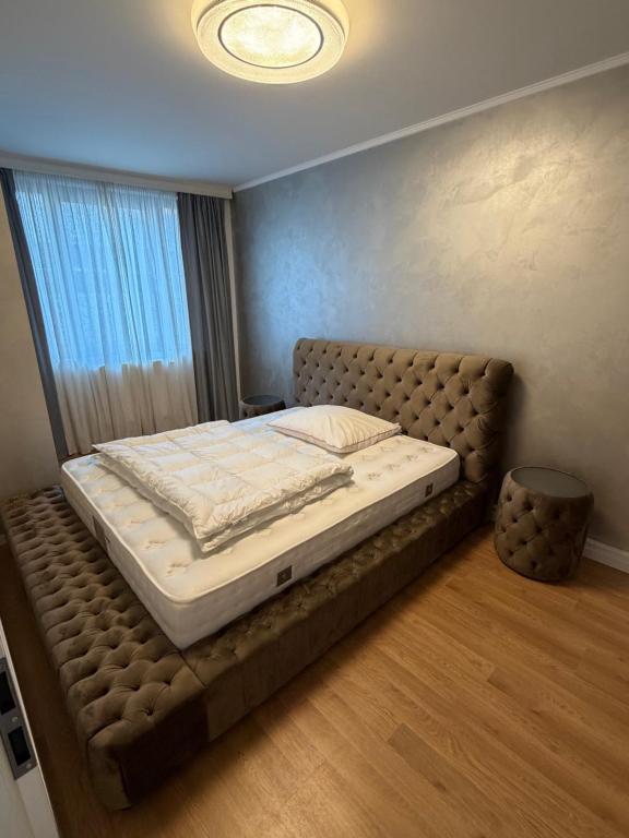 ein großes Bett in einem Schlafzimmer mit großem Fenster in der Unterkunft Next to the Presidential Palace in Bratislava