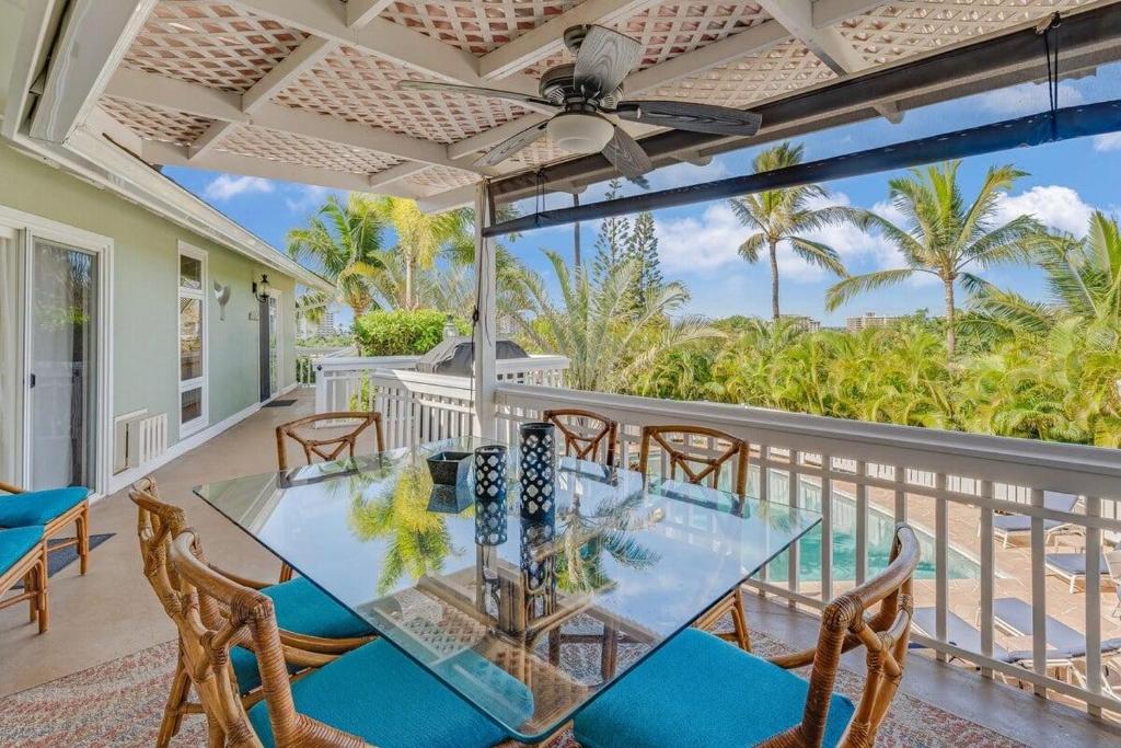 Hyatt Regency Maui Hotel HeliportHale Vista · VISTA Tropical Getaway at Kaanapali House to Relax的阳台的用餐室配有玻璃桌和椅子