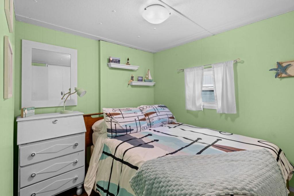 a bedroom with a bed and a dresser and a mirror at Beautiful Decorated Cozy Retreat in Rockaway Beach