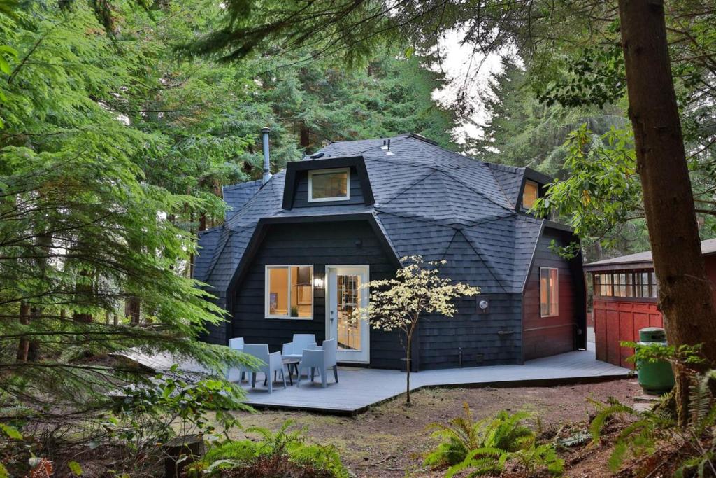 a black shingled house in the woods at Hidden Dome Retreat in the Trees in Barview