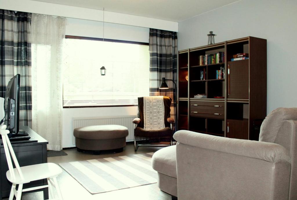 - un salon avec un canapé, une chaise et une fenêtre dans l'établissement Convenient Apartment for 3 in Varissuo, à Littoinen