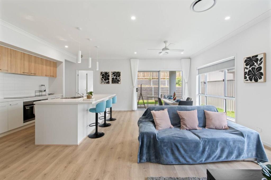 a living room with a blue couch and a kitchen at Modern House with Patio and Family Comfort) in Park Ridge