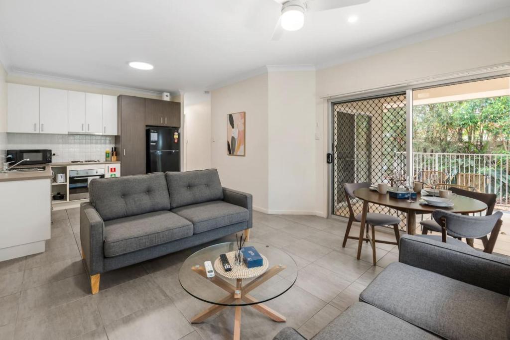 a living room with a couch and a table at Charming 2BR Home in Serene Mount Warren Park in Windaroo