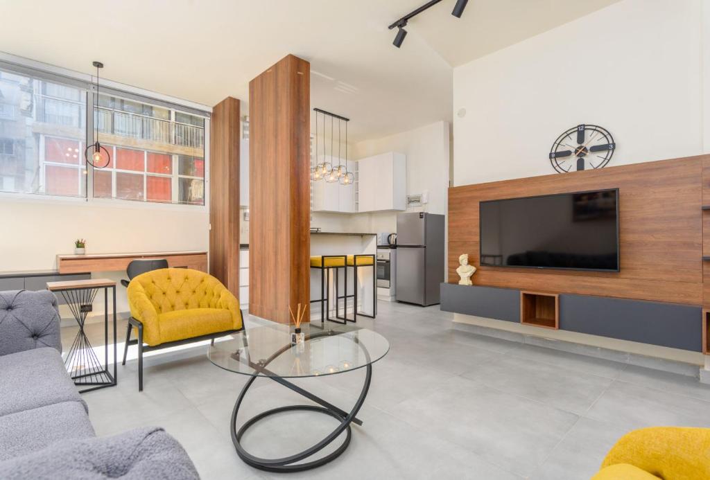 a living room with a couch and a tv at Curl 2-Bedroom Apartment in Gemmayzeh in Ar Rumayl