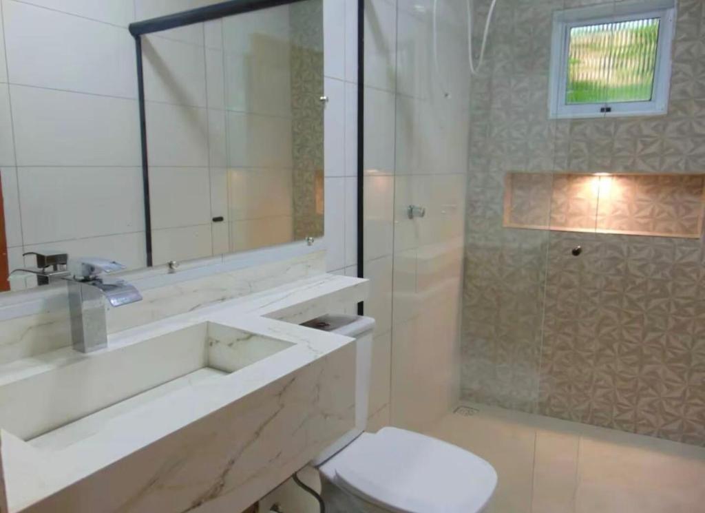 a bathroom with a sink and a toilet and a shower at Pousada Bela Flor in São Thomé das Letras