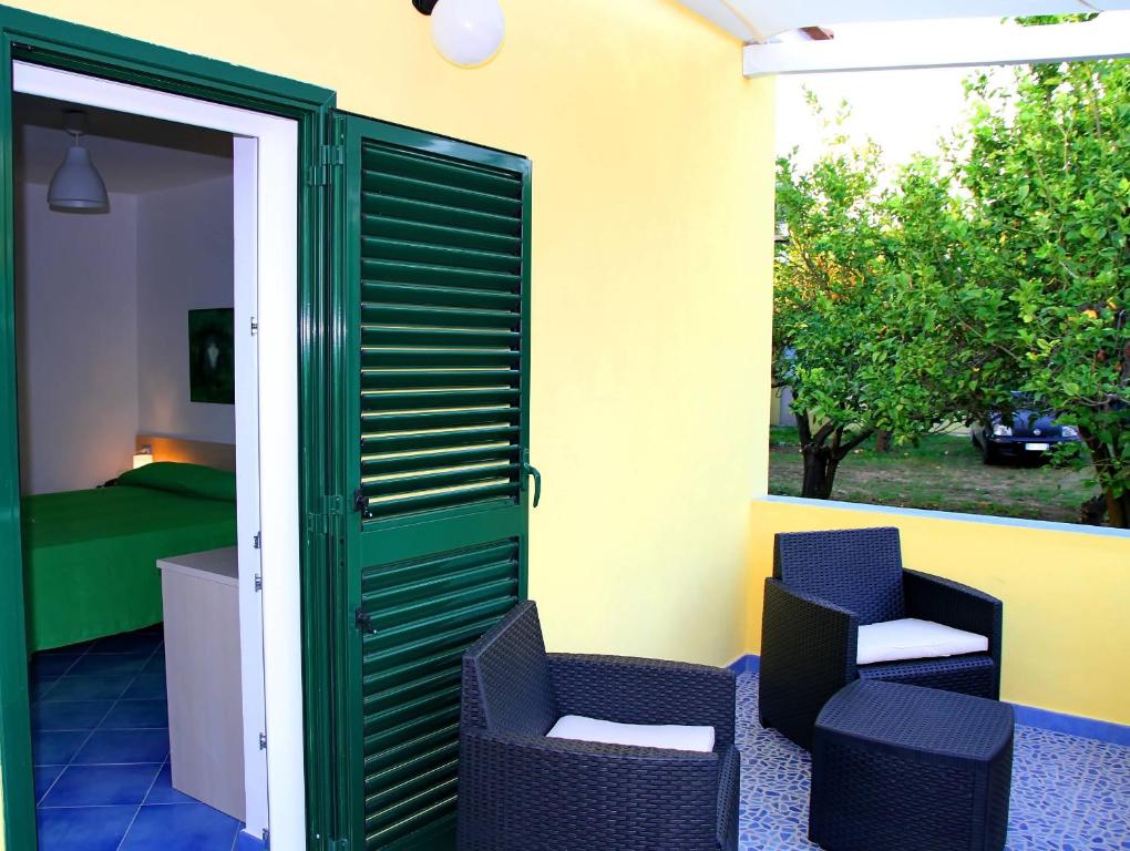 a patio with two chairs and a door to a bedroom at Belvedere in Procida