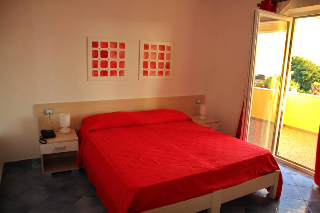 a bedroom with a red bed and a window at Belvedere in Procida