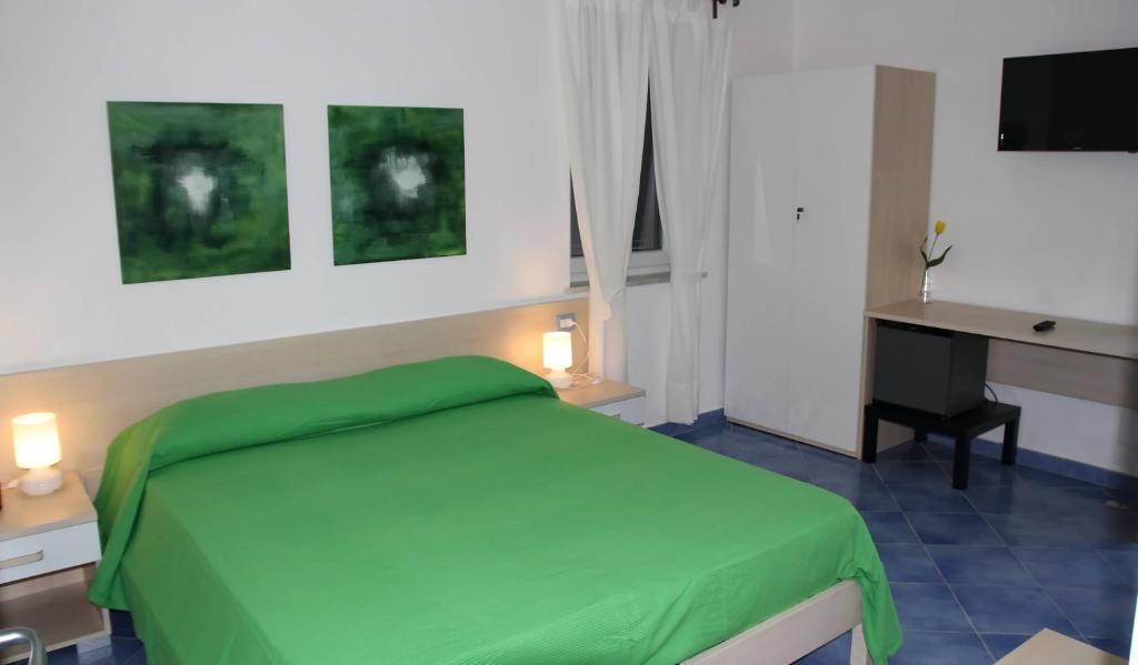 a bedroom with a green bed and a desk at Belvedere in Procida