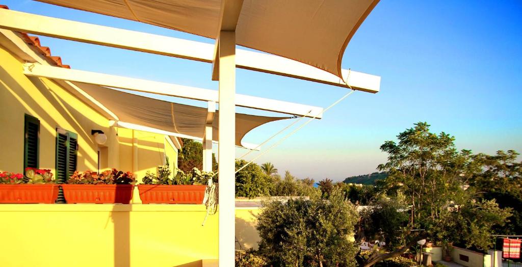 two pictures of a house with awning on a balcony at Belvedere in Procida