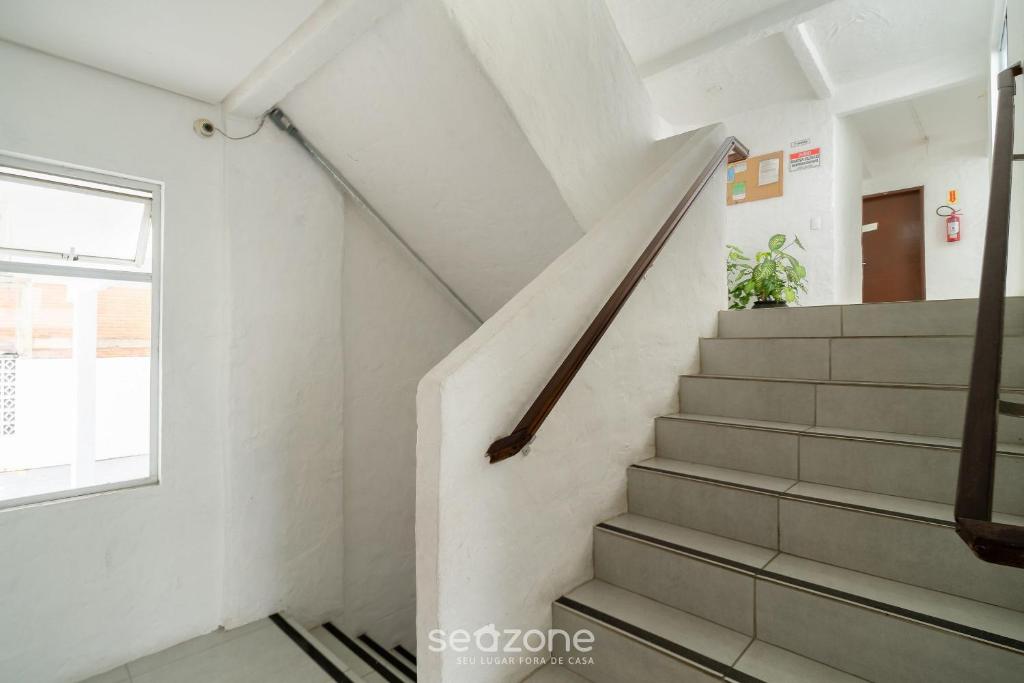 a staircase in a room with a window at Aptos em prédio a 500m da Praia de Canasvieiras - GALs in Florianópolis