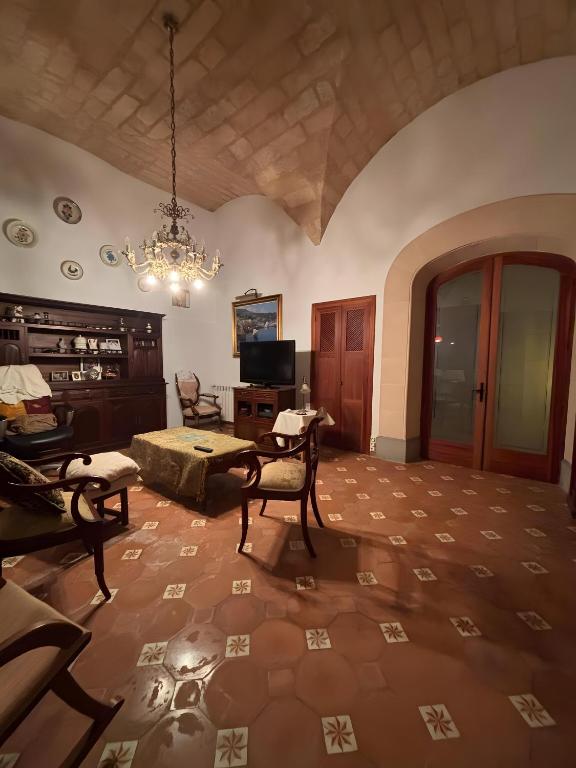 a living room with a chandelier and a table and chairs at Sa Torre in Campos
