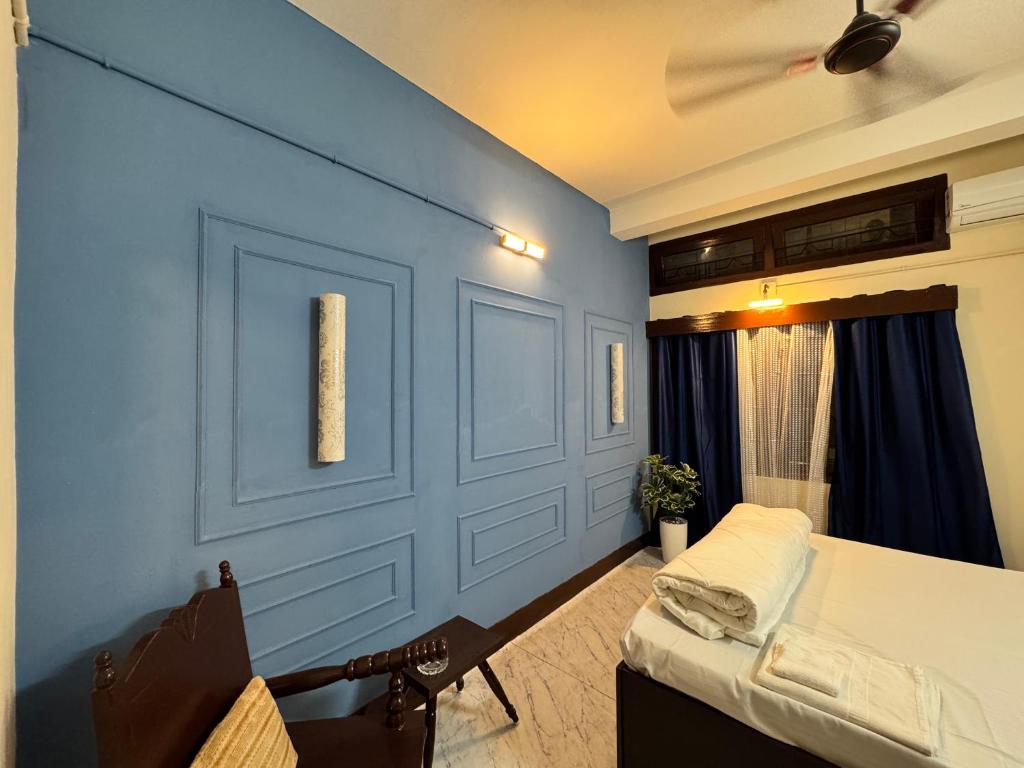 a bedroom with a bed and a blue wall at Varnas Cosy Stay in Guwahati