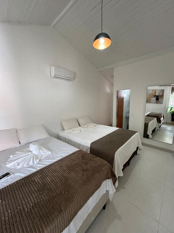 une chambre avec deux lits et un miroir dans l'établissement Gute Morro Villa Apartments, à Cairu