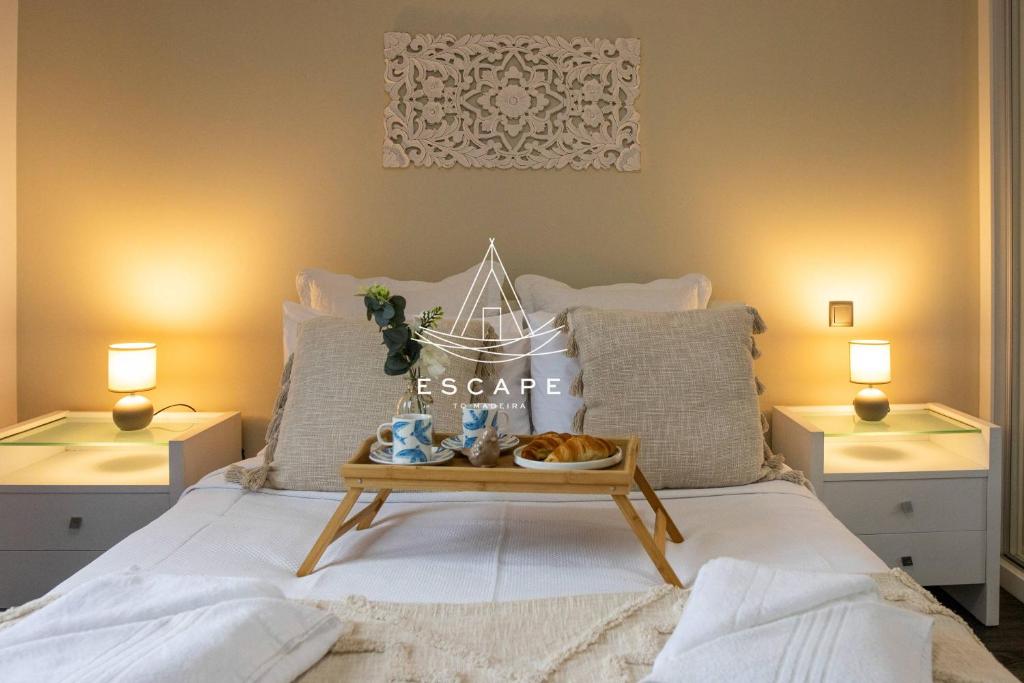a bedroom with a bed with a tray of food on it at Cottage Bela Vista by Escape to Madeira in Cedros