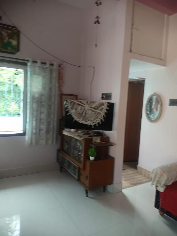 a living room with a tv and a window at Urban Nest Homestay 3BHK full furnished in Mullāhjor