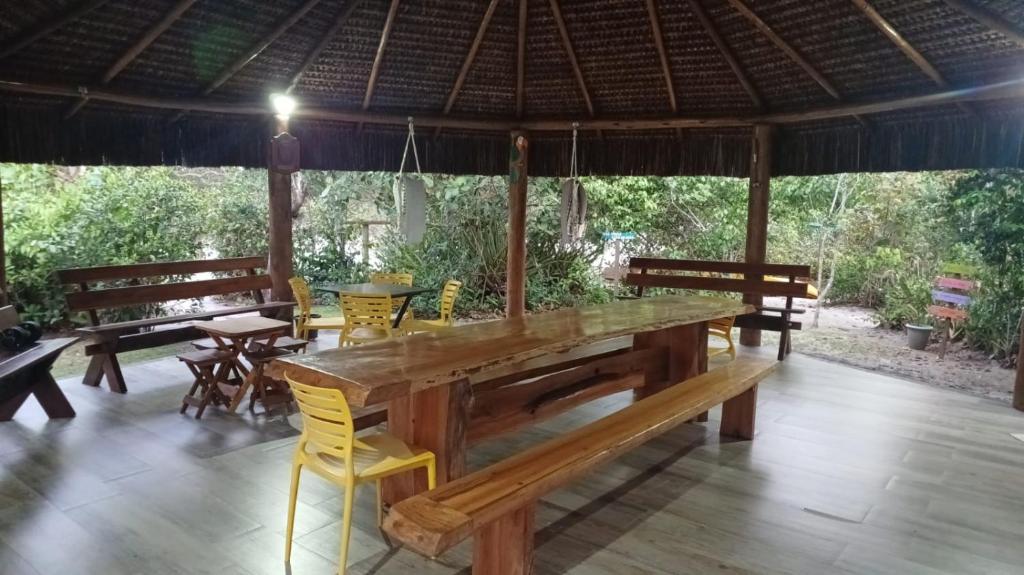 a large wooden table and chairs in a pavilion at Passos da Lagoa in Itapemirim