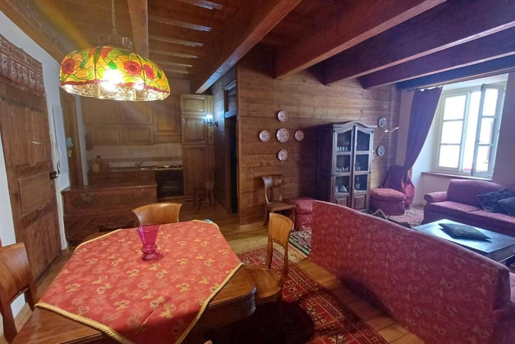 a dining room with a table and a couch at Apartment with fireplace near the Vauban City in Briançon