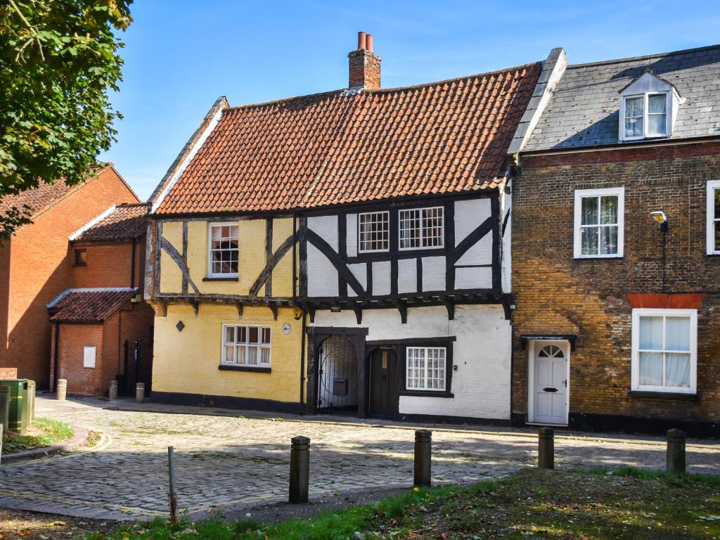 ein altes schwarz-gelbes Haus in einer Straße in der Unterkunft The Old Sweet Shop in Kings Lynn