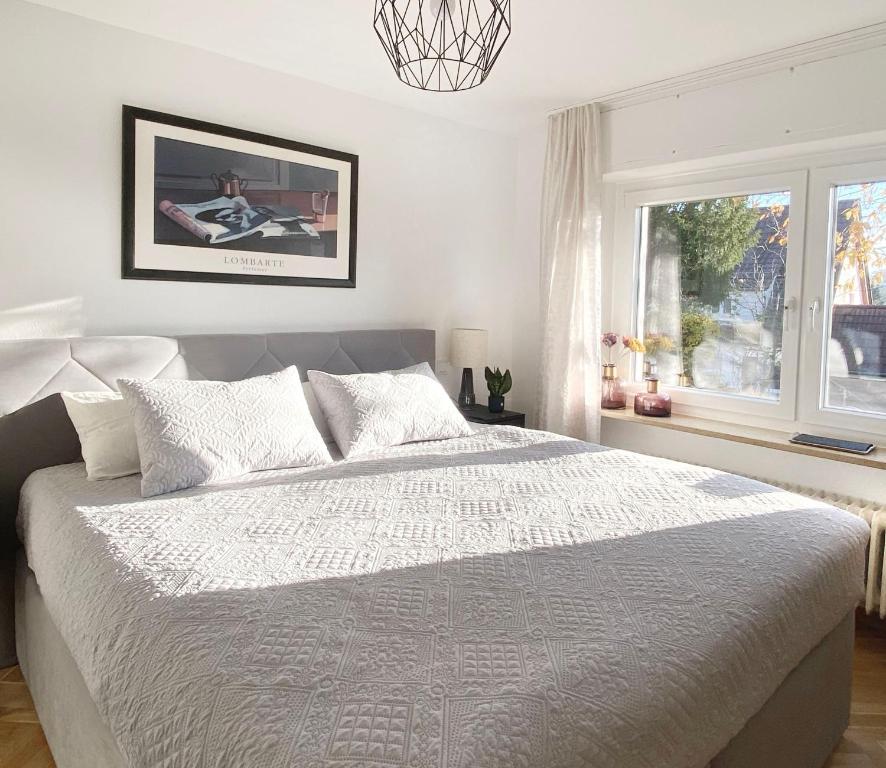 een slaapkamer met een wit bed en een raam bij Apartment ANi, E-Parkplatz Göppingen 2Zi, 60qm zentrale Wohnung, Zweifamilienhaus, Terrasse, Garten, ruhig, direkt an Fahrradstraße, nahe EWS Arena in Göppingen