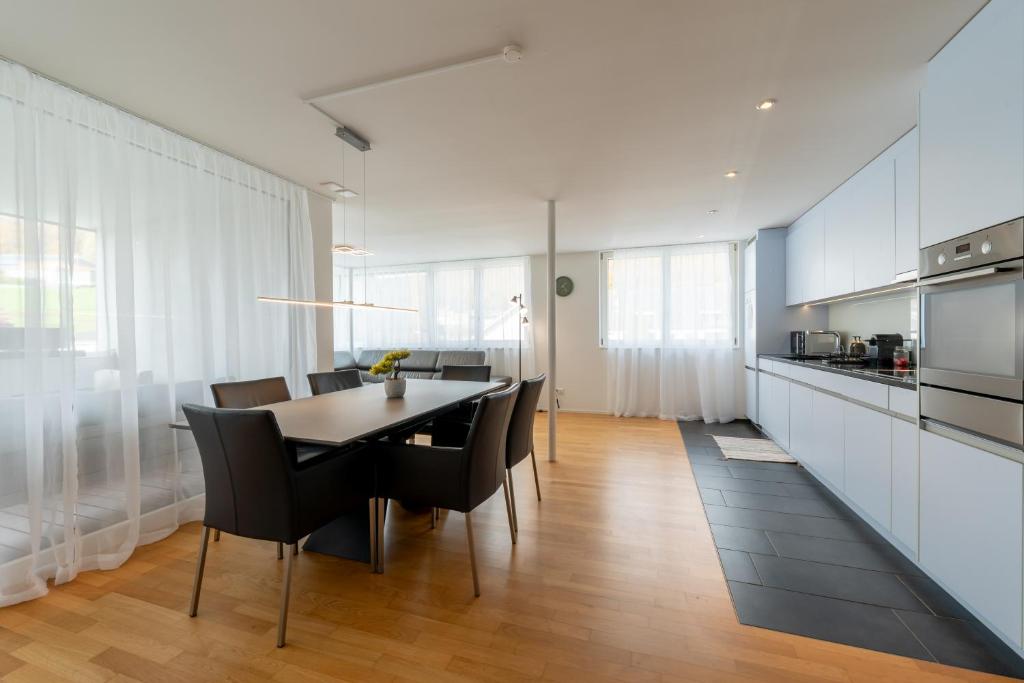 a kitchen and dining room with a table and chairs at Swiss Suites - Stusslingen in Lostorf