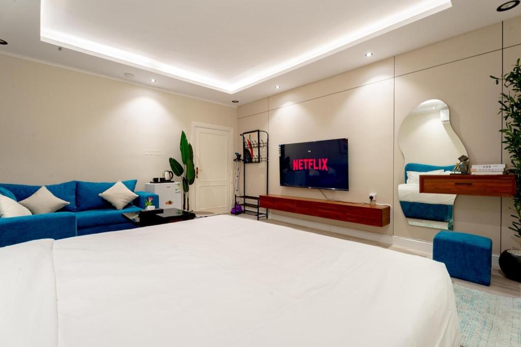 a bedroom with a white bed and a blue couch at استديو رائع في العليا 203 in Riyadh