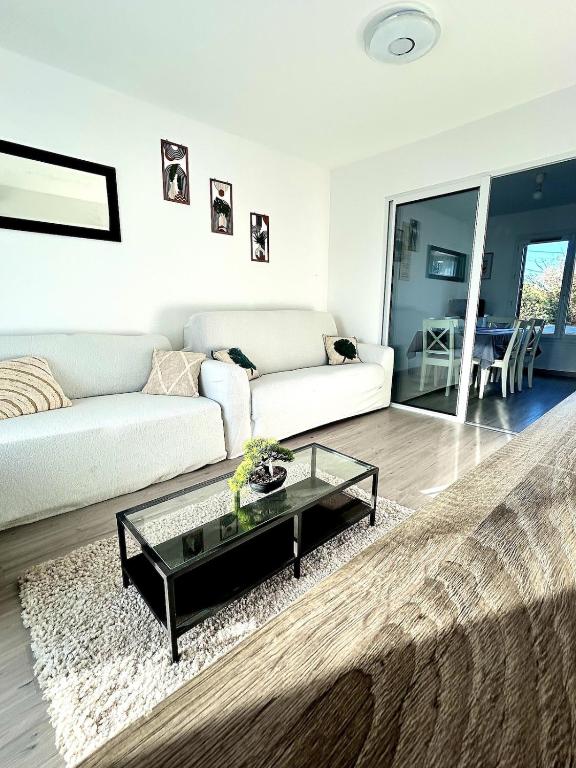 Maison cosy في غوسافييل: غرفة معيشة بها أريكة وطاولة قهوة