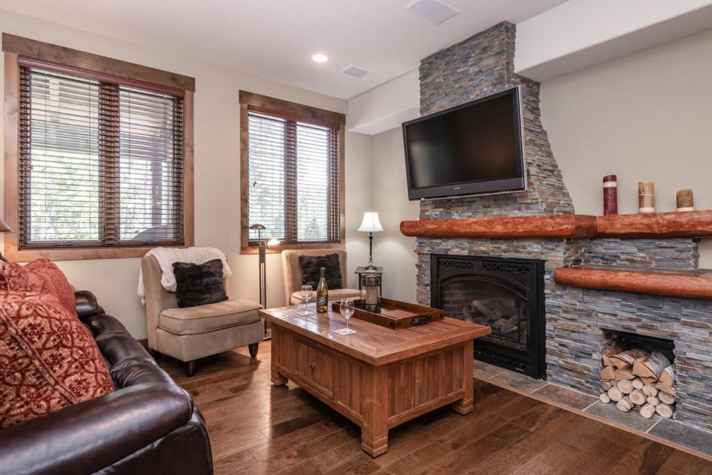 Una sala de estar con un sofá y una chimenea. en Woodwinds 22, en Mammoth Lakes