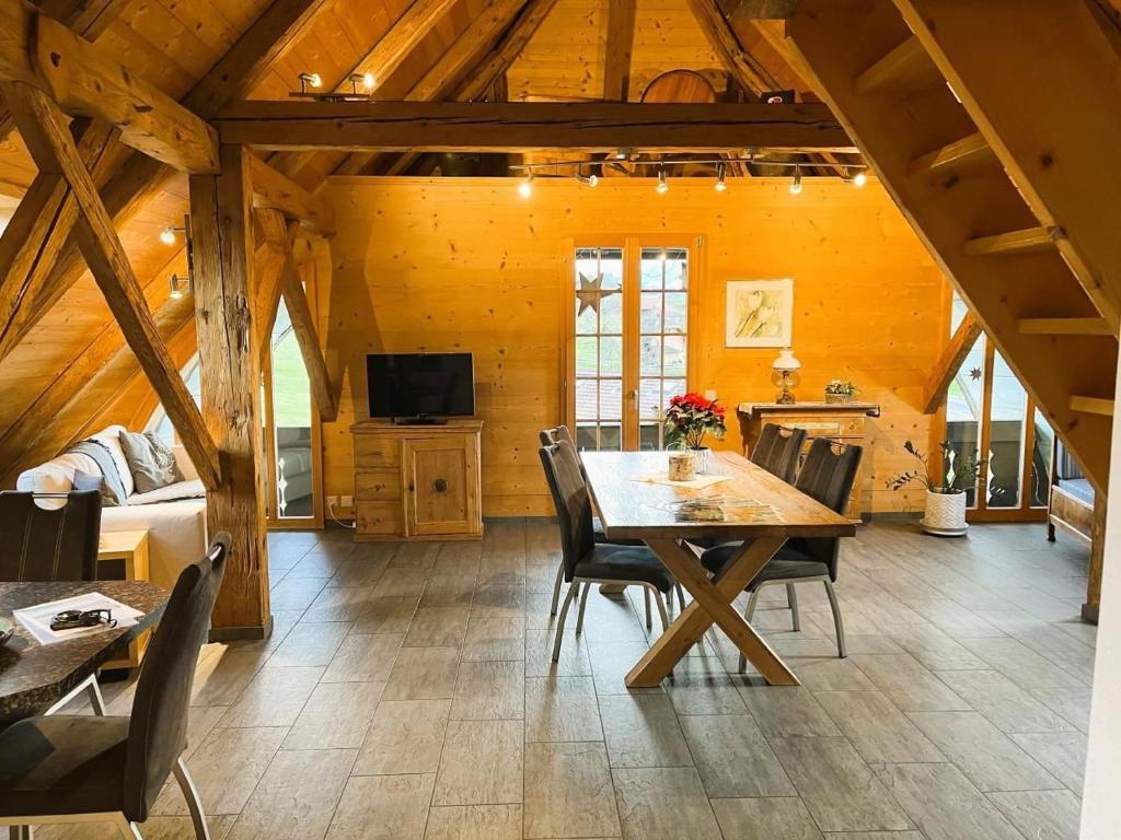 a dining room with a wooden table and chairs at Haus Itten in Hondrich