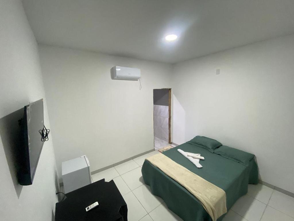 a small room with a bed and a television at Sol Dos Lençois Pousada in Barreirinhas