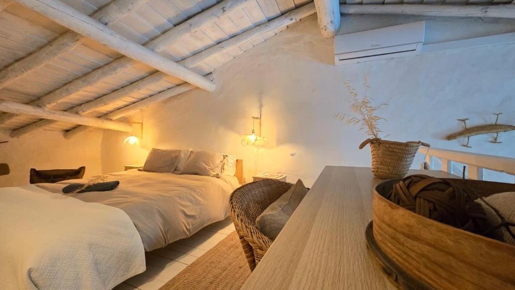 a bedroom with two beds and a table at Villa Oliva São Pedro in São Pedro do Corval