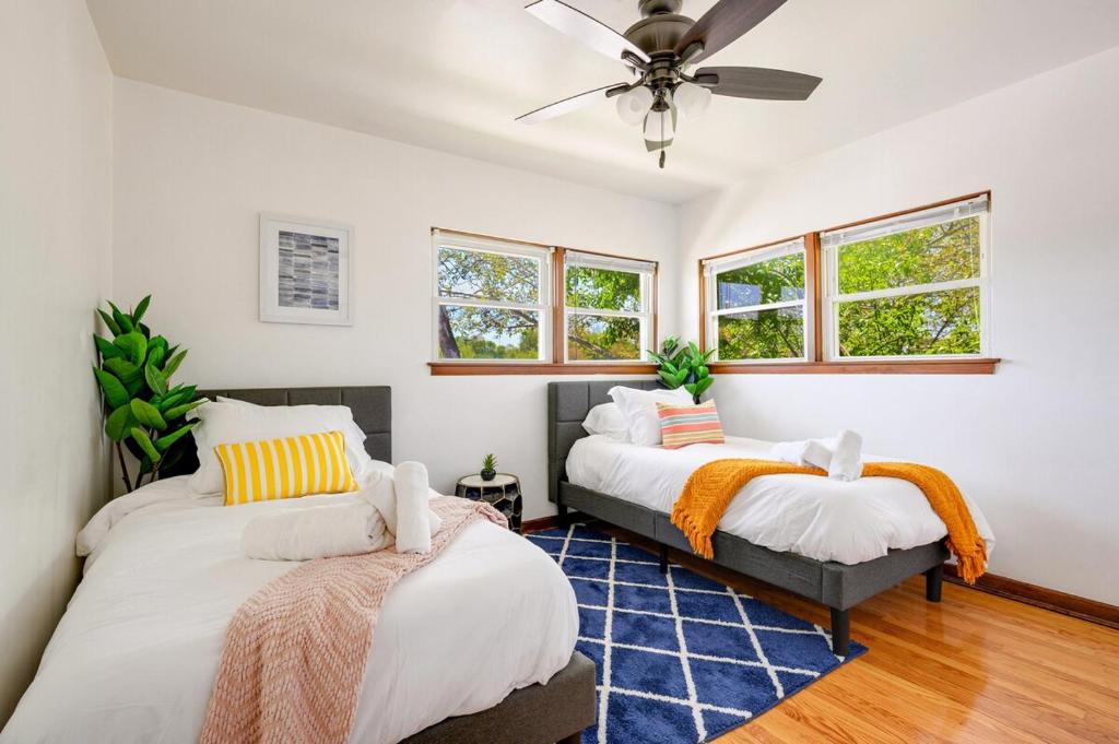 two beds in a room with white walls and windows at Curated for Cozy Longer Stays in Westmont
